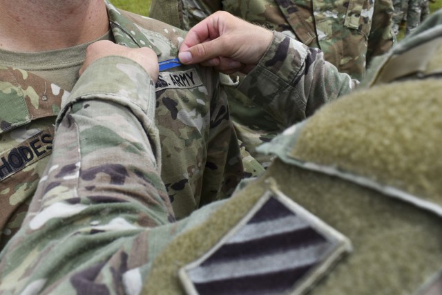 Staff Sgt. Codi Rhodes, an Expert Infantry Badge recipient assigned to the 3rd Battalion, 15th Infantry Regiment, 2nd Armored Brigade Combat Team, 3rd Infantry Division, receives his badge at Fort Stewart, Georgia, Aug. 20, 2021. EIB candidates...