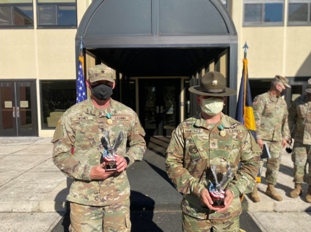 Staff Sgt. Juan Martinez and Spc. Joseph Twomey holding their trophies they received from Center for Initial Military Training Command Sgt. Maj. Scott Beeson for winning Fort Eustis Best NCO and Soldier of the Year.