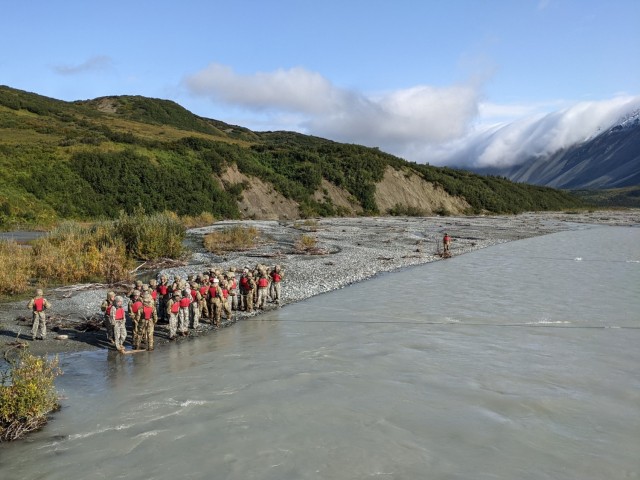 Students in the Basic Military Mountaineering Course wait their turn to cross the swiftly flowing, 38-degree water of Phelan Creek on August 18. The 15-day course takes place at the Black Rapids Training Site of the Northern Warfare Training Center in central Alaska. (Photo by Eve Baker, Fort Wainwright Public Affairs Office)