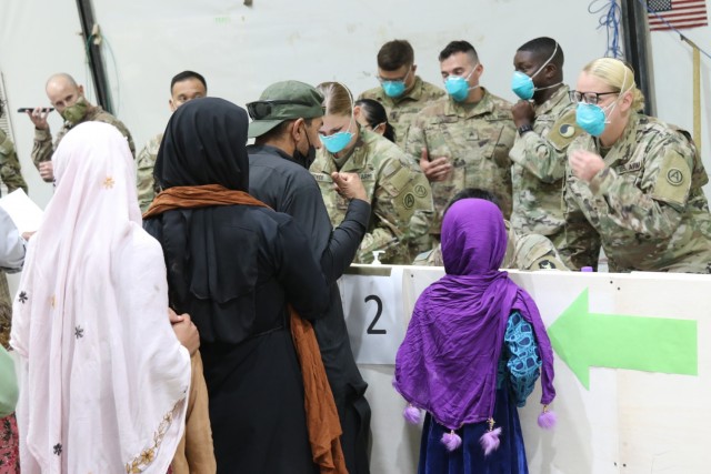 U.S. Army National Guard Soldiers with Task Force Spartan, U.S. Army Central, welcome and offer immediate assistance to Afghan evacuees as they arrive at Camp Buehring, Kuwait, Aug. 23, 2021. U.S. Army Soldiers continue to work with their U.S....