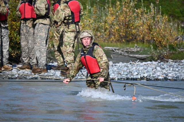 Sgt. Jordan Haag crosses Phelan Creek in central Alaska on August 18 during the Basic Military Mountaineering Course conducted at the Black Rapids Training Site of the Northern Warfare Training Center. The source of the creek is Gulkana Glacier, and the water temperature was approximately 38 degrees Fahrenheit. The river crossing was the final event of the 15-day course. (Photo by Eve Baker, Fort Wainwright Public Affairs Office)
