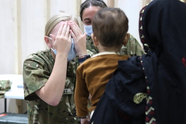 A U.S. Army National Guard Soldier with Task Force Spartan, U.S. Army Central, plays a quick game of peekaboo with an Afghan child who recently arrived at Camp Buehring, Kuwait, Aug. 23, 2021. U.S. Army Soldiers continue to work with their U.S....
