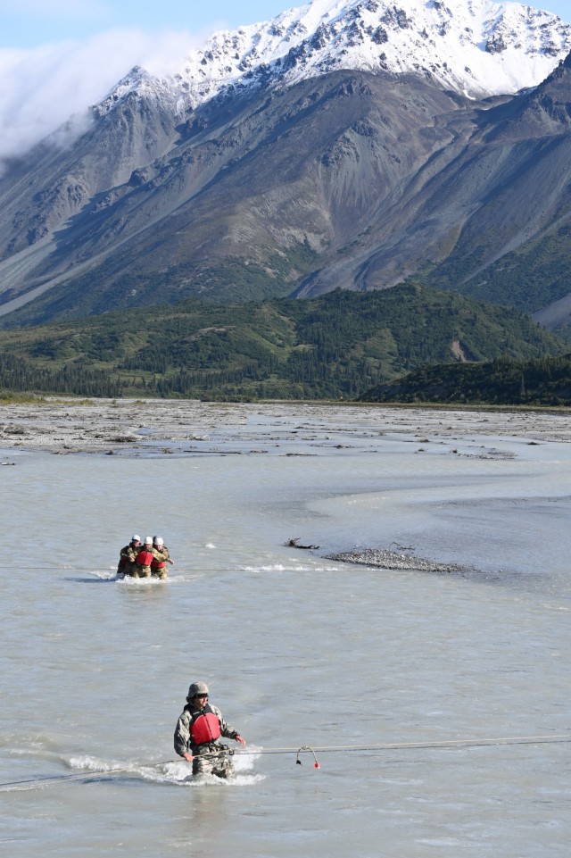 A student (foreground) of the Basic Military Mountaineering Course crosses Phelan Creek on the final day of the course, while a group of leaders from U.S. Army Alaska (background) practices an un-roped river crossing technique. The creek’s source is Gulkana Glacier in the Alaska Range, and the water temperature on the day of the crossing was approximately 38 degrees Fahrenheit. (Photo by Eve Baker, Fort Wainwright Public Affairs Office)