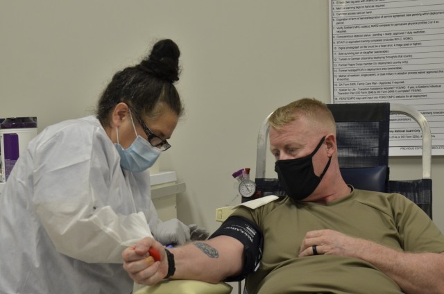 Naomi Brigg, phlebotomist with the Armed Services Blood Program, draws blood from Sgt. 1st Class Jason Womack, 2nd Battalion, 502nd Infantry Regiment, 2nd Brigade Combat Team, 101st Airborne Division (Air Assault) Aug. 24 during a blood drive at the Soldier Support Center.