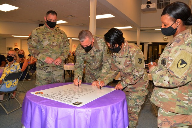 Maj. Gen. Mark T. Simerly, CASCOM and Fort Lee commanding general, and Col. Karin L. Watson, Fort Lee garrison commander, sign the Suicide Awareness and Prevention Month pledge during an observance kickoff breakfast Aug. 26 at the Memorial Chapel Family Life Center. Flanking the senior leaders are Command Sgt. Maj. Jorge C. Escobedo and CSM Tamisha A. Love, the top enlisted leaders for the respective organizations. (U.S. Army photo by Patrick Buffett)