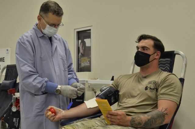 Edward Smith, phlebotomist with the Armed Services Blood Program, prepares to draw blood from Spc. Jason Justice, 1st Squadron, 75th Cavalry Regiment, 2nd Brigade Combat Team, 101st Airborne Division (Air Assault), Aug. 24 during a blood drive at the Soldier Support Center.