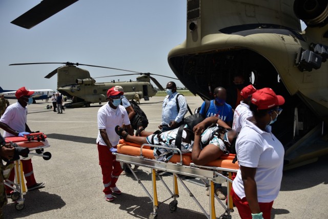 A U.S. Army CH-47 Chinook Helicopter crew and partner rescue agencies transfer a patient following a medical evacuation in Port-au-Prince, Haiti, Aug. 23, 2021. The Coast Guard conducted humanitarian efforts in impacted areas of Haiti following a...