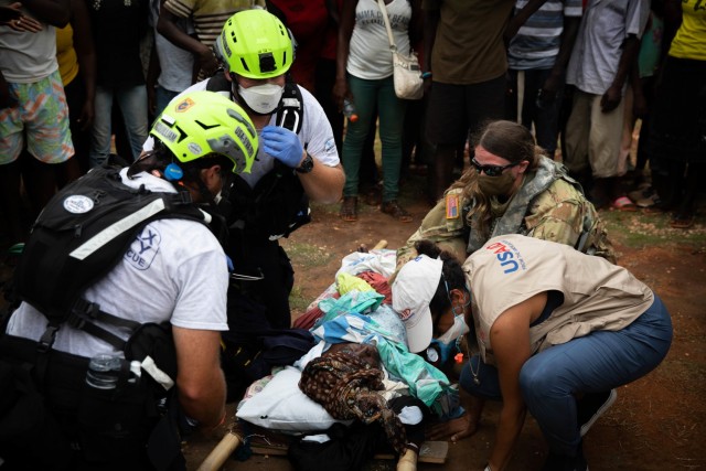 SGT Amberlynn Hinckley assist members of the Disaster Assistance Response Team (DART) while performing first aid to a local woman from the La Flandre community in Haiti, Aug.22, 2021. Guardsmen from the Puerto Rico Army National Guard Aviation...