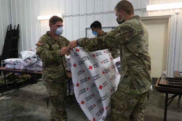 U.S. Soldiers assigned to 509th Clearance Company fold blankets for Afghans arriving at Fort McCoy, Wisconsin, Aug. 26, 2021. The Department of Defense, through U.S. Northern Command, and in support of the Department of State and Department of Homeland Security, is providing transportation, temporary housing, medical screening, and general support for up to 50,000 Afghan evacuees at suitable facilities, in permanent or temporary structures, as quickly as possible. This initiative provides vulnerable Afghans essential support at secure locations outside Afghanistan. (U.S. Army photo by Spc. Eric Cerami/ 55th Signal Company)