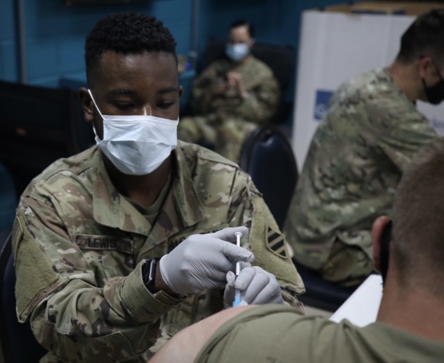 Spc. Dorien Lewis, a combat medic with Division Sustainment Troops Battalion MEDOPS, 3rd Division Sustainment Brigade, administers the Moderna COVID-19 vaccine to a U.S. Army Soldier, Aug. 17, 2021. (U.S. Army photo Sgt. Marquis Hopkins)