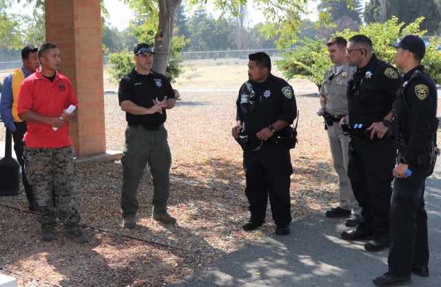 Left to right, Deputy Rueben Delapena and Sgt Kyle Benner, exercise proctors from the Santa Clara County Sheriff’s Office, conduct an after action review with members of first law enforcement responder contact team, Police Officer Alan Corpuz from the Mountain View Police Department, California Highway Patrol Officer C. Geels, Public Safety Officer B. McMoore, Public Safety Officer S. Kotani, both from the Sunnyvale Department of Public Safety (Law), during active-shooter response training, at the Sgt. James Witowski Armed Forces Reserve Center, in Mountain View, California, Aug. 26, 2021.