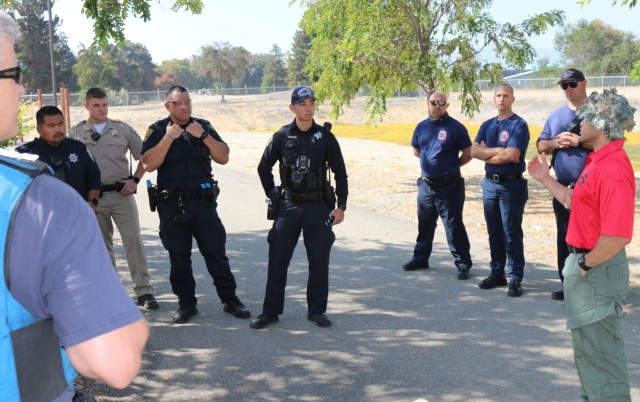 Left to right, Police Officer Alan Corpuz from the Mountain View Police Department, California Highway Patrol Officer C. Geels, Public Safety Officer B. McMoore, Public Safety Officer S. Kotani, both from the Sunnyvale Department of Public Safety (Law), members of first law enforcement responder contact team, and emergency medical services and fire department personnel listen to feedback from Deputy Brent Bugarin, Santa Clara County Sheriff’s Office, during active-shooter response training, at the Sgt. James Witowski Armed Forces Reserve Center, in Mountain View, California, Aug. 26, 2021.