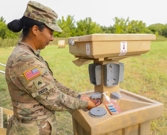 U.S. Army Sgt. Maria Anaya, a culinary specialist noncommissioned officer assigned to 511th Quartermaster Company, Special Troops Battalion, 1st Sustainment Brigade, 1st Infantry Division, washes her hands before entering a mobile kitchen trailer,...