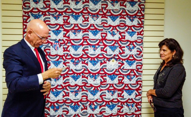 Franklin Childress, director of Army Reserve communications, and Diane Murtha, a former Marine Corps spouse, read prayers and messages out of a remembrance quilt, previously donated from U.S. Post Office customers and staff at Catawissa, Penn.