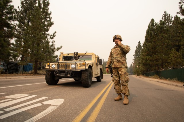 U.S. Army Spc. Dace Taylor, from the California Army National Guard’s 270th Military Police Company, talks to another Soldier Sept. 1, 2021, in South Lake Tahoe, California, as the Caldor Fire encroaches on the evacuated city. Cal Guard...