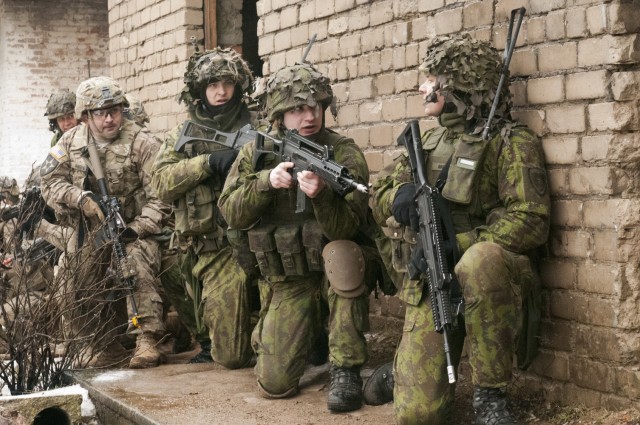 Lithuania Soldiers alongside U.S. troops prepare to enter and clear a building during an offensive operations exercise at the Pabrade training center, Lithuania, Feb. 26, 2015. Dragoons of Lightning Troop, 3rd Squadron, 2nd Cavalry Regiment and Lithuania Soldiers of 3rd Company, Algirdas Mechanized Infantry Battalion conducted combined operations during a three-day field training exercise in support of Operation Atlantic Resolve. (U.S. Army photo by Staff Sgt. Megan Leuck)