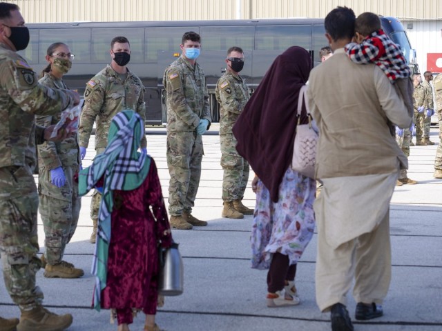 Afghan evacuees arrive in Indianapolis Sept. 2, 2021, as 1st Cavalry Division Soldiers watch. Hoosiers will host the Afghans at Camp Atterbury, near Edinburgh, as they resettle in the United States. The division Soldiers and Indiana National Guard Soldiers will provide transportation, temporary housing, medical screening and logistics support as part of Operation Allies Welcome. (Photo by Sgt. Tackora Farrington)