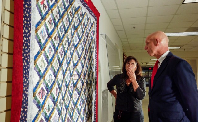 Franklin Childress, director of Army Reserve communications, and Diane Murtha, a former Marine Corps spouse, look at the photos of 9/11 victims printed across a remembrance quilt on display at the Pentagon Quilts memorial, Washington D.C., Aug....