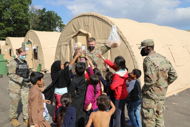 U.S. Army Soldiers from 18th Military Police Brigade and 16th Sustainment Brigade hand out bread to children in support of Operation Allies Refuge September 02, 2021 at Ramstein Air Base, Germany. Soldiers from the 21st Theater Sustainment command...