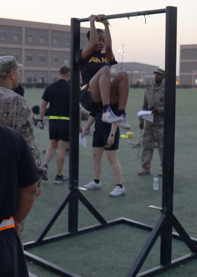 Sgt. Britteny Walton, deployed to Camp Arifjan, Kuwait, with the Fort Bragg, N.C., based 3rd Expeditionary Sustainment Command, executes the leg tuck during the unit's Sept. 7, 2021, Army Combat Fitness Test familiarization event. Walton said she focused on improving her score on the leg tuck by making it part of her workout routine, as well as, stopping to perform one or two leg tucks, whenever she walks around the camp and comes upon a leg tuck iron bar.
