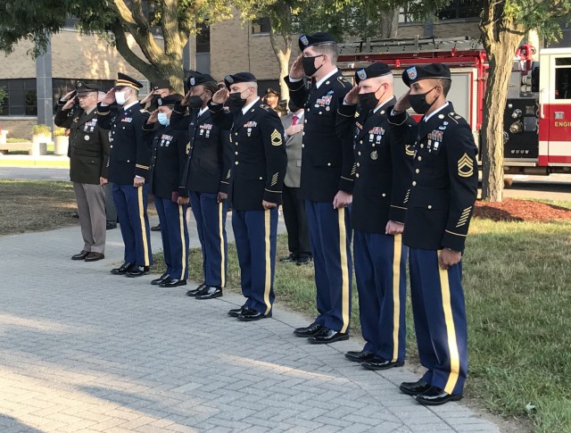 Soldiers stand at attention as the national flag is lowered to half staff