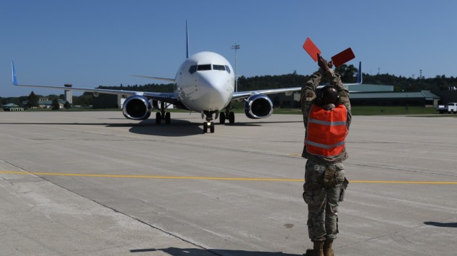 An aircraft transporting vulnerable Afghans is guided at Volk Field on Camp Douglas Wisconsin, Aug. 22, 2021. (U.S. Army photo by Sgt. William Washburn)