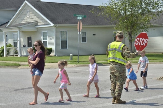 Specialist Jayden Wallace, 163rd Military Police Company, 716th Military Police Battalion, helps Brooke Hernandez and her children – Harlie, 1, left; Lily, 5; Maci, 6; Parker, 3; and Carson, 8; through a traffic crossing near Barkley Elementary School. Recently the Tennessee Highway Safety Office recognized Fort Campbell traffic officers for their exemplary traffic management and contribution to vehicular safety, this includes helping pedestrians safely cross roads. The Fort Campbell Police Traffic Section was awarded third place in the Law Enforcement Challenge in the 76-100 officer category and were first in the regional competition with Fort Benning, Ga.