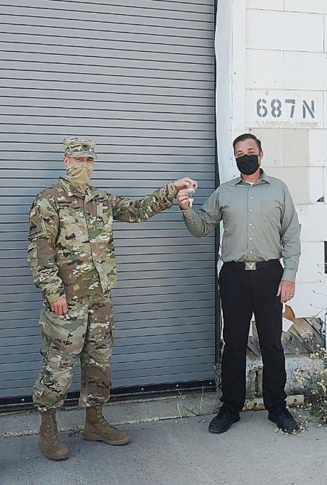 Col. Steve Dowgielewicz, Tooele Army Depot commander, hands the keys to Building 687 to Cameron Dortch of Five Star General Industrial, Inc.  Building 687 is one of five buildings that are being converted into industrial space by Five Star, a locally owned company committed to expanding the Tooele County industrial base.
