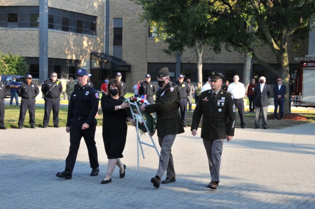 Fireman Rodney Redwood and 1st Sgt. Lowell Chenault escort Carrie Mead and Maj. Gen. Darren Werner to place the wreath honoring all those who perished Sept. 11, 2001.