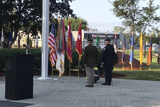 The honor guard pauses in front of the flag pole before lowering the flag to half staff.