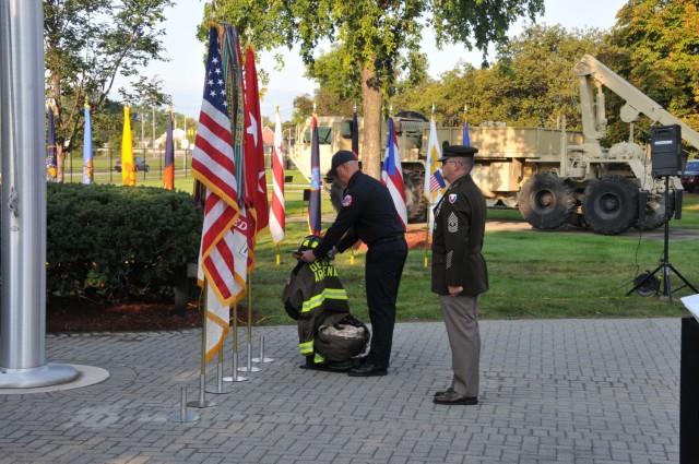 Detroit Arsenal fireman places a helmet to honor the fallen first responders who died on 9/11.