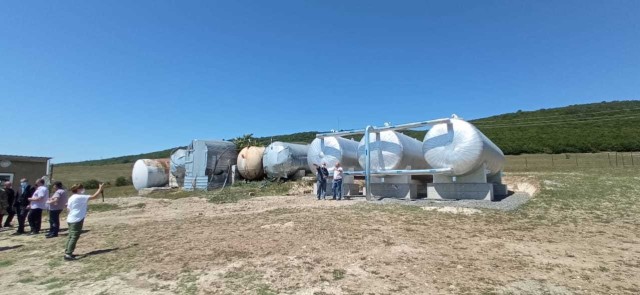 Newly constructed water supply storage tanks serving the Internally Displaced Persons settlement in Prezeti, Georgia and their support pads are visible on the right, next to the storage tanks they are replacing on the left, which show visible...
