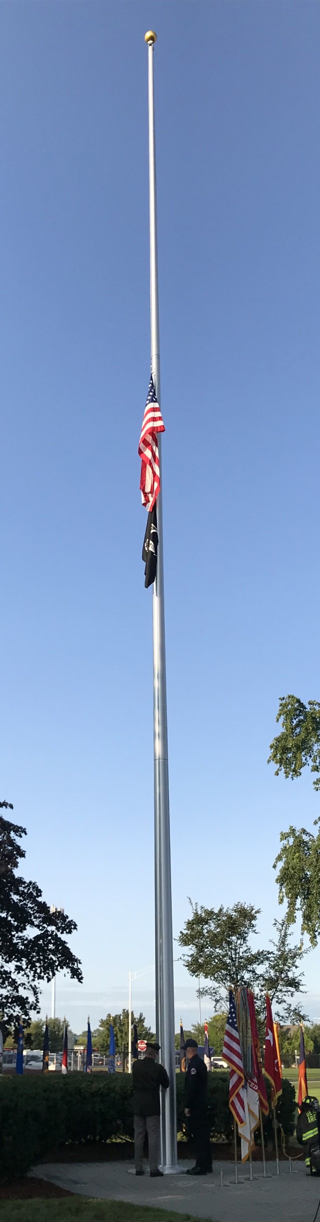 The honor guard at the Detroit Arsenal lower the flag to half-staff.