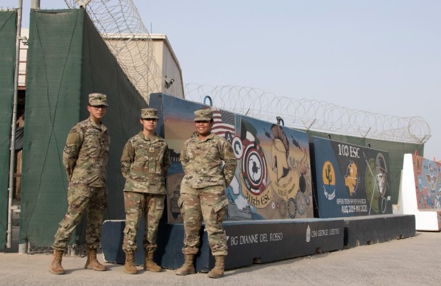 Spc. Miguel A. Martinez, Pvt. 1st Class Janice M. Salazar, and Spc. Onosai Misionare, Soldiers assigned to 3rd Expeditionary Sustainment Command, stand in front of T-walls painted by Soldiers in units who have previously served in 1st Theater Sustainment Command&#39;s operational command post at Camp Arifjan, Kuwait, on Sept. 10, 2021. The Fort Bragg, N.C., based Soldiers deployed in August to assume 1st TSC&#39;s operational command post mission.