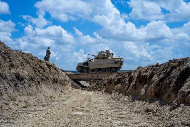 GREYWOLF Troopers with 3rd Brigade Engineer Battalion, 3rd Armored Brigade Combat Team, 1st Cavalry Division, dash across a Joint Assault Bridge (JAB) in a Bradley Fighting Vehicle during a combined arms breach exercise, Fort Hood, Texas, June 6, 2021. The exercise included 3rd Battalion, 8th Cavalry Regiment and 2nd Battalion, 82nd Field Artillery Regiment; marking the first time in history that both an M1A2 SEPv3 Abrams Main Battle Tank and a M109A7 Paladin have crossed over the JAB. (U.S. Army photo by Sgt. Calab Franklin)