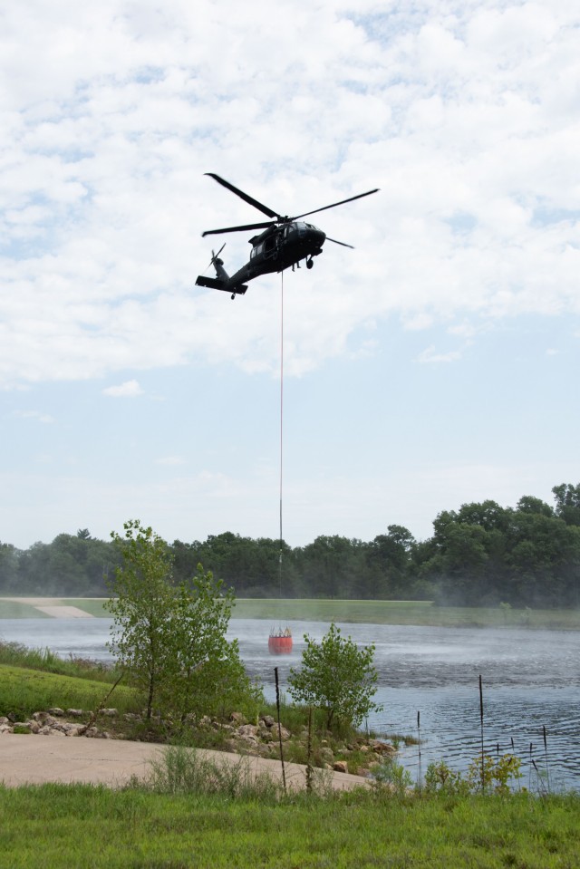 A Wisconsin Army National Guard UH-60 Black Hawk aircrew with the Madison, Wis.-based 1st Battalion, 147th Aviation Regiment train to drop water on wildfires Aug. 12, 2021, using Bambi buckets at a lake at Fort McCoy, Wis., in preparation for...