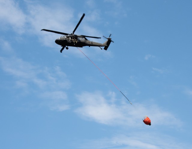 A Wisconsin Army National Guard UH-60 Black Hawk aircrew with the Madison, Wis.-based 1st Battalion, 147th Aviation Regiment train to drop water on wildfires Aug. 12, 2021, using Bambi buckets at a lake at Fort McCoy, Wis., in preparation for...