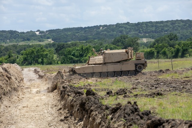 GREYWOLF Engineers with 3rd Brigade Engineer Battalion, 3rd Armored Brigade Combat Team, 1st Cavalry Division, prep a berm for crossing during a combined arms breach exercise, Fort Hood, Texas, June 6, 2021. The exercise included 3rd Battalion, 8th Cavalry Regiment and 2nd Battalion, 82nd Field Artillery Regiment; marking the first time in history that both an M1A2 SEPv3 Abrams Main Battle Tank and a M109A7 Paladin have crossed over the Joint Assault Bridge. (U.S. Army photo by Sgt. Calab Franklin)