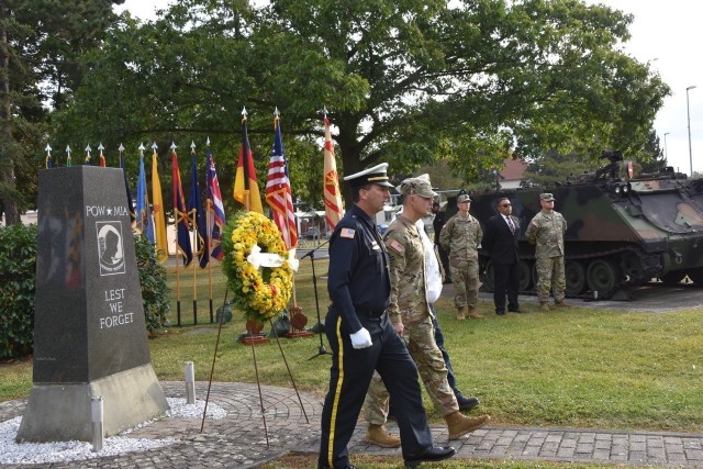 Garrison Police Chief Jason Kesselring, Garrison Command Sgt. Maj. Richard Russell and Garrison Deputy Fire Chief Rodney Millbrooks walk away from the wreath after placing it in Veterans Park.