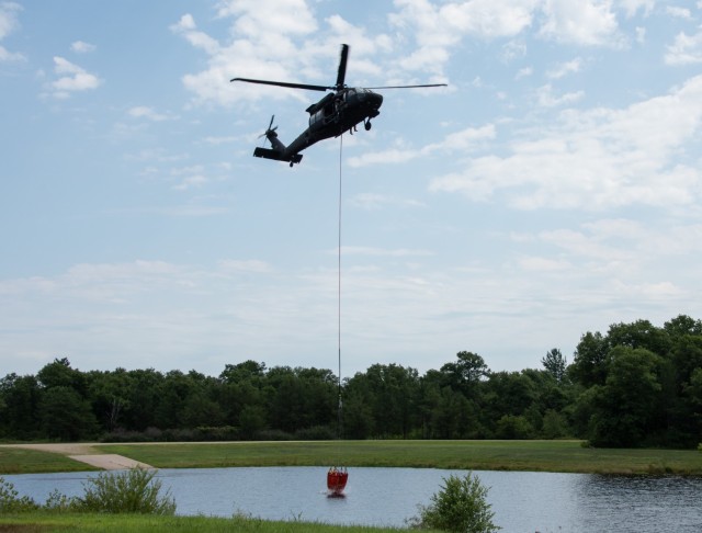 A Wisconsin Army National Guard UH-60 Black Hawk aircrew with the Madison, Wis.-based 1st Battalion, 147th Aviation Regiment train to drop water on wildfires Aug. 12, 2021, using Bambi buckets at a lake at Fort McCoy, Wis., in preparation for...
