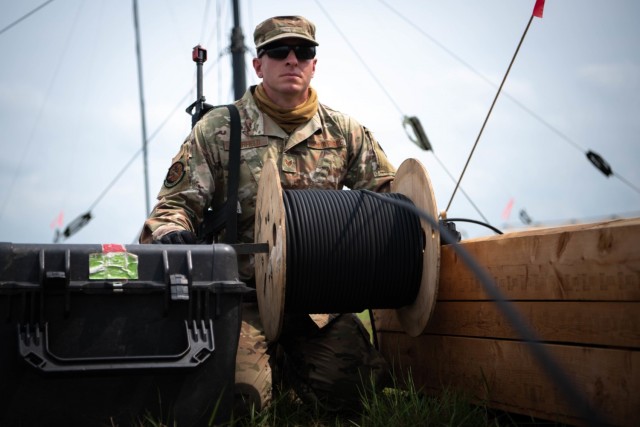 RF transmission system technician Staff sergeant Aaron Fairfield with the 23rd Combat Communication Squadron installs wires during exercise Patriot Warrior at Fort McCoy, Wisconsin, Aug. 10, 2021. The wires connect to radio antennas throughout the...