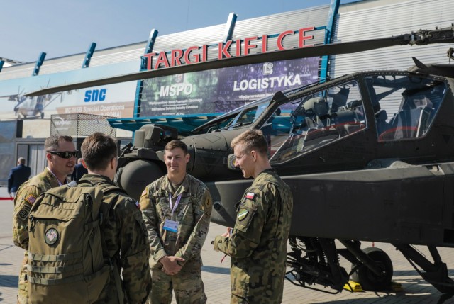 Chief Warrant Officer 2 Michael Weaver (left), an AH-64E Apache pilot, and Spc. Chase Schollmeyer (second from right), an AH-64E Helicopter repairer, both assigned to 1st Battalion, 1st Aviation Regiment, 1st Combat Aviation Brigade, 1st Infantry Division, explain the capabilities of their aircraft to Polish soldiers at an international defense industry exhibition known as Międzynarodowy Salon Przemysłu Obronnego in Kielce, Poland, Sept. 8, 2021. MSPO is a high-profile, international exhibition designed to showcase the latest land, sea, air and national security defense systems and military projects to a highly specialized audience from the Polish and international community. The 1st Infantry Division represented the U.S. Army at the event, showcasing equipment reflecting their armored and aviation rotational forces currently supporting Atlantic Resolve across Europe. 