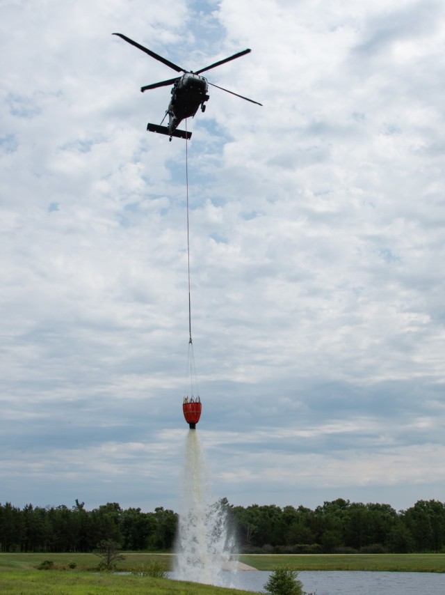 A Wisconsin Army National Guard UH-60 Black Hawk aircrew with the Madison, Wis.-based 1st Battalion, 147th Aviation Regiment train to drop water on wildfires Aug. 12, 2021, using Bambi buckets at a lake at Fort McCoy, Wis., in preparation for...