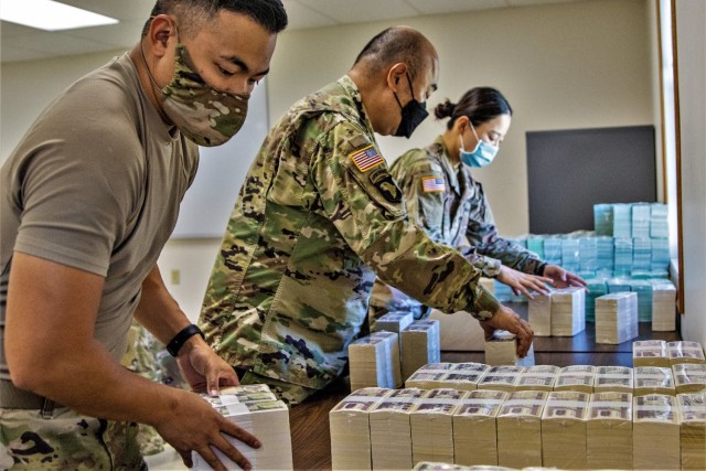 (Left to right) Capt. Cynjun Salinas, Lt. Col. Luke Ahn, and Spc. Saralin Moon, 326th Financial Management Support Center Soldiers, stack simulated currency Aug. 14, 2021, after moving their operation in less than two hours during the Diamond Saber exercise at Fort McCoy. Diamond Saber is an Army Reserve-led exercise that incorporates participation from all components and joint services, and it prepares finance and comptroller Soldiers on the warfighting functions of funding the force, payment support, disbursing operations, accounting, fiscal stewardship, auditability, and data analytics. (U.S. Army photo by Mark R. W. Orders-Woempner)