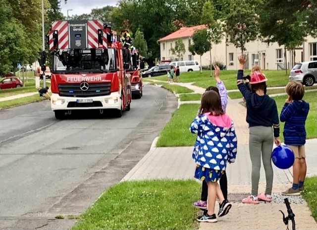 Excited children waive as emergency vehicles pass during the parade.