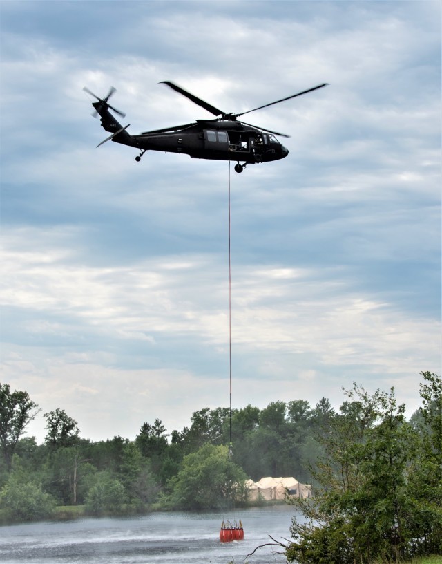 A Wisconsin Army National Guard UH-60 Black Hawk aircrew with the Madison, Wis.-based 1st Battalion, 147th Aviation Regiment train to drop water on wildfires Aug. 12, 2021, using Bambi buckets at a lake at Fort McCoy, Wis., in preparation for...