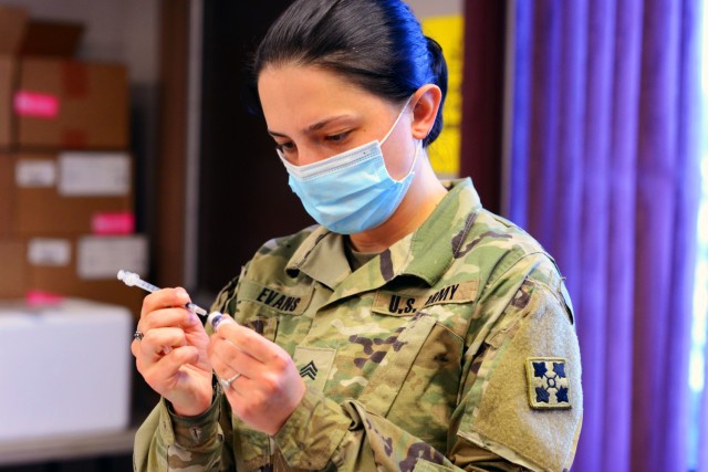 Sgt. Morgan Evans, a combat medic specialist assigned to 2nd Stryker Brigade Stryker Team, 4th Infantry Division, prepares a dose of the Pfizer-BioNTech COVID-19 vaccine at the COVID-19 vaccination site located in the William “Bill” Reed...