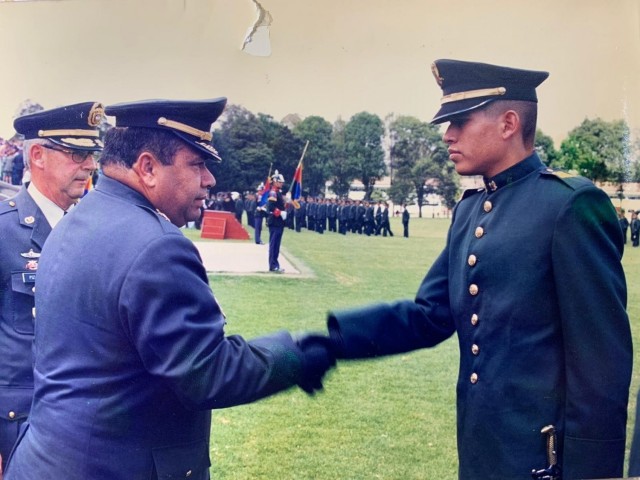 Cadet Mauricio Garcia shakes hands with the school commander during graduation from military officer school in Bogota, Colombia. Garcia, now a Chief Warrant Officer with the U.S. Army, is deployed to Tolemaida Army Base in Colombia as part of a...