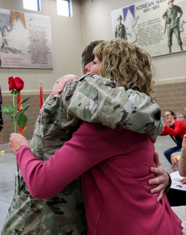 Spc. Tyler Strasser, a cavalry scout with 1st Squadron, 113th Cavalry Regiment, Iowa Army National Guard, presents a rose to his mother, Jessica Strasser, during the change of responsibility ceremony for the 2nd Infantry Brigade Combat Team, 34th...