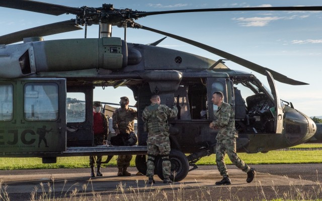 U.S. Army Chief Warrant Officer 3 Mauricio Garcia, left inside Black Hawk door, and his Colombian safety officer counterpart, Capt. Cristian Castiblanco, inspect a refueling operation at Tolemaida Army Base in Colombia. Garcia, a UH-60M Black Hawk pilot and aviation safety officer, is deployed here as part of a technical advising team from U.S. Army Security Assistance Command’s Fort Bragg-based training unit, the Security Assistance Training Management Organization.